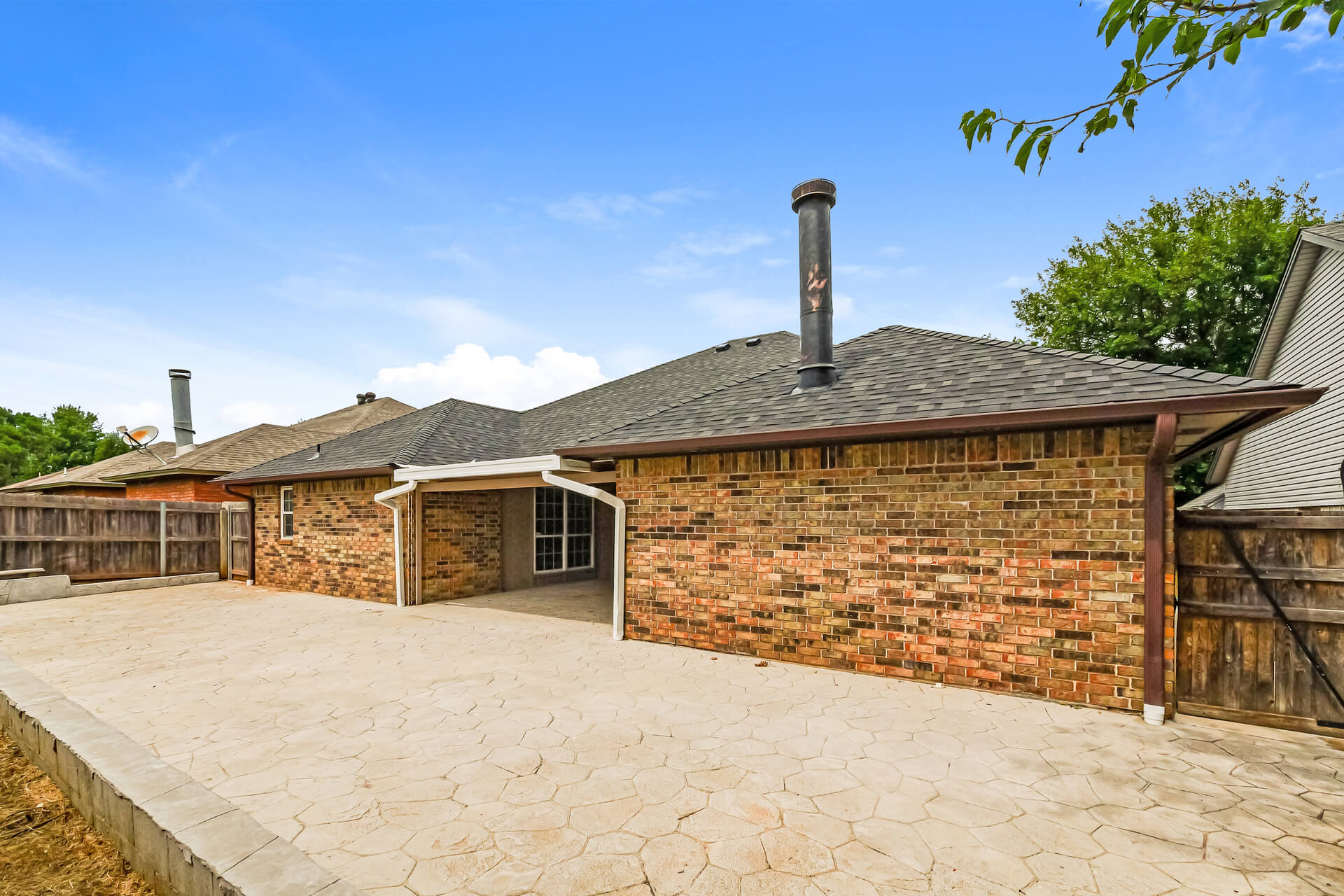 property management midwest city ok rental home Brick single-family rental home in Midwest City, OK with a large stamped concrete patio, covered back porch, and privacy fence, managed by a local property management company